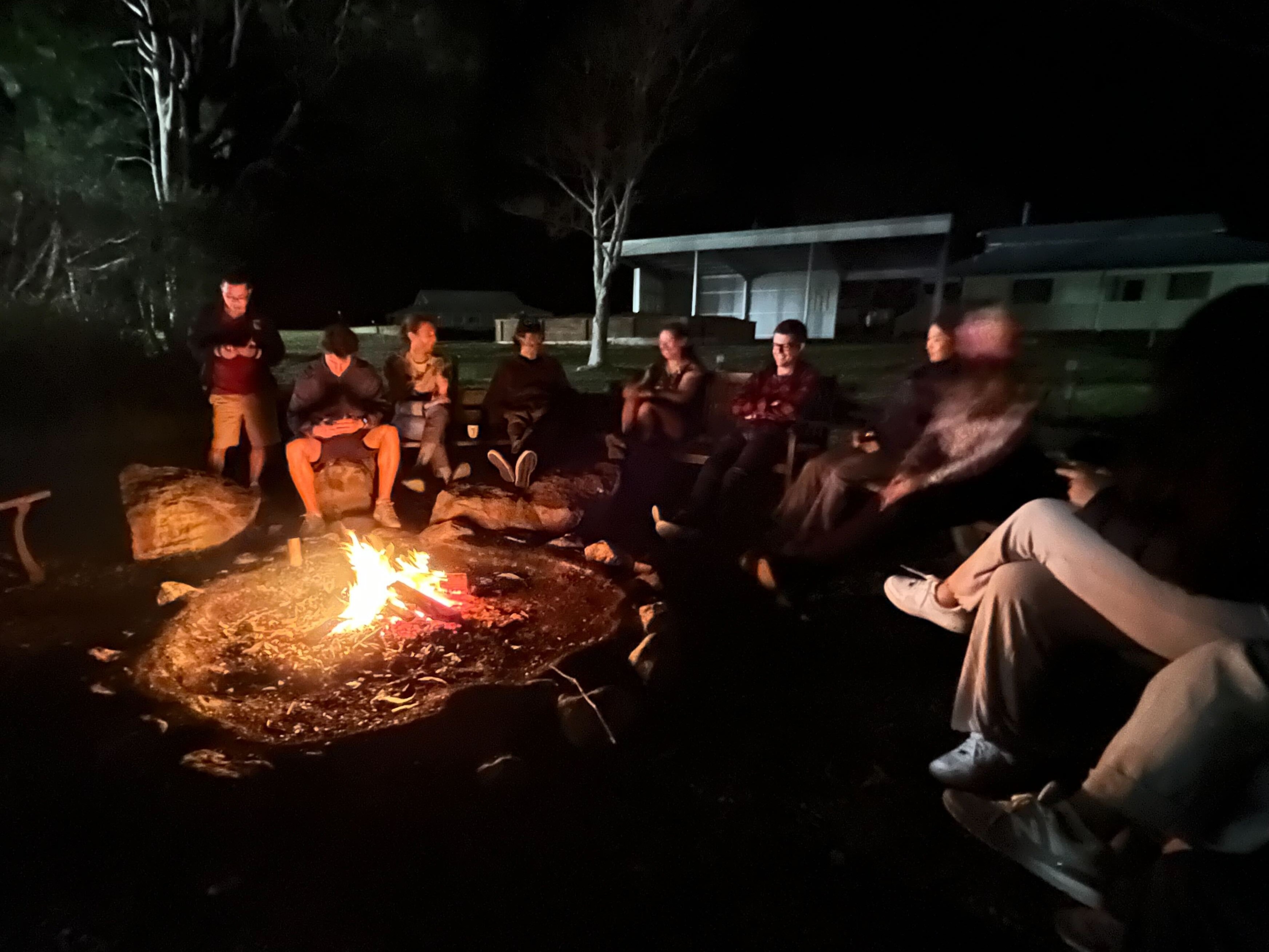 A bunch of us sitting around the outdoor fire at night